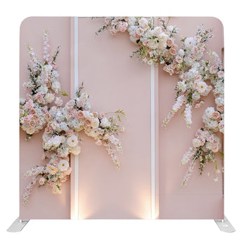 Decoratief bloemenwand paneel met kunstbloemen in roze, wit en beige tinten, geplaatst tegen een roze achtergrond.